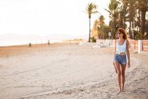 Femme mince en vêtements d'été se promener sur la plage tropicale — Photo de stock