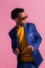 Dandy black man in jacket standing on pink background — Stock Photo