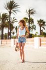 Slim woman in summer clothes standing on tropical beach — Stock Photo