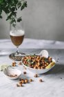 Composition of bowl filled with baked spicy chickpeas on table with drink in vintage glassware — Stock Photo