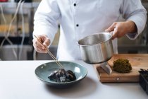 Chef che serve piatti di pesce nordico con cozze sul piatto — Foto stock