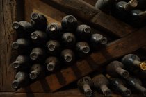 Coffre à vin plein de bouteilles sur des étagères en bois sombre — Photo de stock
