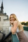 Portrait of happy young woman standing on bridge — Stock Photo