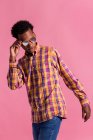 Stylish hipster man in checkered sunglasses and shirt on pink background — Stock Photo