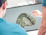 Dentist modeling jaw on computer — Stock Photo