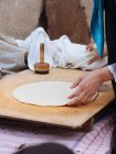 Mani femminili rotolamento foglio di pasta su tavola di legno — Foto stock