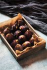 Fresh figs on parchment in wooden box — Stock Photo