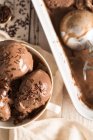Крупный план домашнего шоколадного мороженого в миске и в коробке — стоковое фото