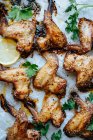 Backblech mit Pergament und gebackenen Hühnerflügeln in Sesam und Petersilie mit Zitrone — Stockfoto