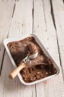 Crème glacée au chocolat maison en boîte avec cuillère sur une surface en bois — Photo de stock