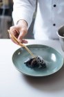Primo piano dello chef che serve piatti di pesce nordico con cozze sul piatto — Foto stock