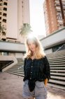 Blonde junge Frau steht vor Treppe auf der Straße — Stockfoto