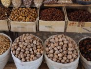 Säcke und Kisten gefüllt mit verschiedenen Nüssen und Gewürzen auf Bauernmarkt — Stockfoto