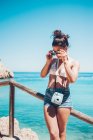 Giovane ragazza in abiti estivi appoggiata su corrimano in legno sulla spiaggia — Foto stock