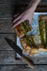 Human hand taking piece of asparagus pie — Stock Photo