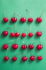 Top view of a group of cherries on green background — Stock Photo