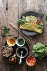 Вьетнамский блинчик с овощами и ингредиентами на деревянном столе — стоковое фото