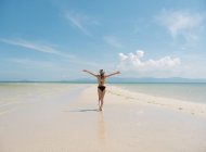 Frau im Badeanzug spaziert an der Sandküste am Meer in Thailand — Stockfoto