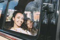 Молода жінка і блондинка сидить всередині машини і дивиться на камеру — стокове фото