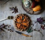 Leckere gebackene Kürbisgalette mit süßen Zwiebeln auf rustikalem Holztisch — Stockfoto