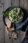 Köstliche Tzatziki-Vorspeise serviert mit Pita in Schüssel auf Holztisch — Stockfoto