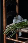 Primo piano di mazzo di asparagi verdi freschi su sedia su sfondo nero — Foto stock