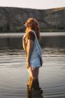 Sensual young woman standing in clear water of lake — Stock Photo