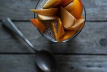Delicioso pudín de chía con mango en vidrio sobre mesa de madera - foto de stock