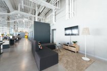 Vue intérieure du nouveau bureau à aire ouverte avec des meubles colorés sur le lieu de travail et la lumière des fenêtres — Photo de stock