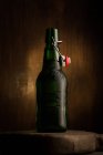 Garrafa de cerveja na placa de madeira no fundo escuro — Fotografia de Stock