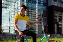 Attraktiver junger Mann sitzt auf Oldtimer-Fahrrad — Stockfoto