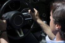 Close-up of man holding steering wheel while driving car — Stock Photo