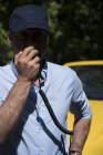 Mann spricht im Radio vor modernem gelben Auto — Stockfoto