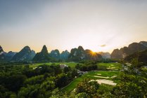 Campos de arroz e montanhas rochosas únicas ao pôr do sol, Guangxi, China — Fotografia de Stock