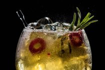 Primer plano de burbujeante gin tonic rojo con pepino y pimienta - foto de stock