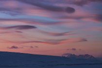 Nubes en el cielo dramático de la noche sobre el paisaje de invierno, Svalbard, Noruega - foto de stock