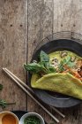 Вьетнамский блинчик с овощами на тарелке на деревянном столе — стоковое фото