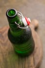Bottiglia di birra fredda su tavola di legno — Foto stock