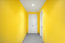 Puertas blancas en corredor amarillo moderno - foto de stock