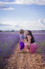 Schwangere mit Kind ruht im Lavendelfeld — Stockfoto