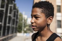Portrait of afro young boy with earring standing outdoors — Stock Photo
