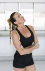 Athlète femme avec les mains couvertes de craie debout dans la salle de gym pendant l'entraînement — Photo de stock