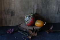 Composição de abóbora colorida em peça de madeira no fundo escuro — Fotografia de Stock