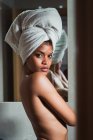 Sedutor mulher topless com toalha na cabeça de pé no banheiro — Fotografia de Stock