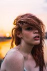 Allettante donna lentigginosa che copre gli occhi con i capelli in natura al tramonto — Foto stock