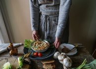 Руки, що беруть тарілку зі смачним артишоковим хумусом — стокове фото