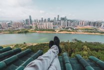 Legs of  tourist on rooftop with cityscape on background, Nanning, China — Stock Photo