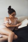 Sensuale bruna donna lettura libro a letto — Foto stock