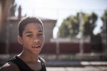 Portrait de jeune afro garçon debout à l'extérieur dans la lumière du soleil — Photo de stock
