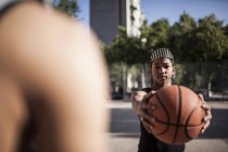 Joven afro chico celebración baloncesto en cancha de barrio - foto de stock